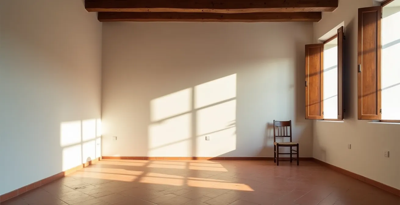 Vista minimalista di una stanza italiana con luce naturale che filtra attraverso persiane, creando un'atmosfera di quiete